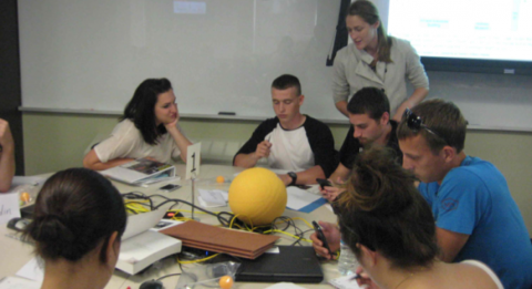 Forbes lab PhD student Gaby Hamerlinck (standing) working with students in a UI TILE classroom 